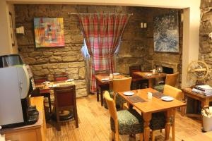 a restaurant with tables and chairs and a stone wall at The Inn At Kingsbarns in St Andrews