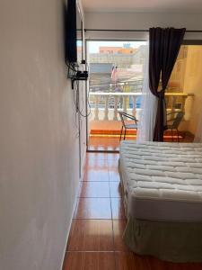 a bedroom with a bed and a view of a balcony at Zigal hotel in Antofagasta