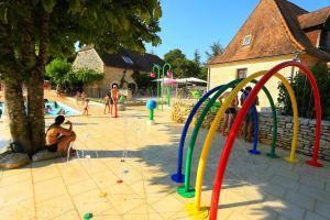 a group of people playing in an outdoor playground at Camping Domaine de la Paille Basse - Maeva in Souillac