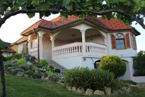a large white house with a balcony and a yard at Villa Lotus in Štrigova