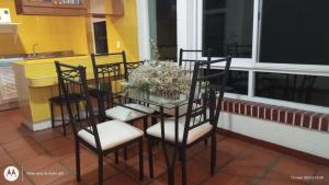 a dining room table with chairs and a glass table at Villa del Palmar departemento in Manzanillo