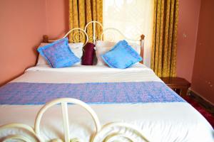 a bedroom with a bed with blue pillows on it at Havan Furnished Apartments-Greensteads in Lake View Estate