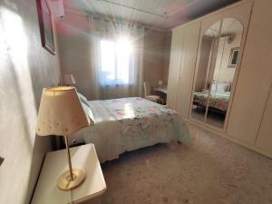 ein Schlafzimmer mit einem Bett mit einer Lampe und einem Spiegel in der Unterkunft metro C and Tor Vergata in Rom