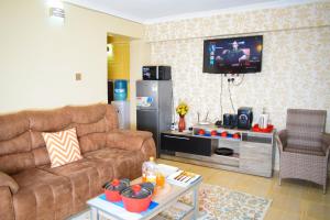 a living room with a couch and a tv at Havan Furnished Apartments-Greensteads in Lake View Estate