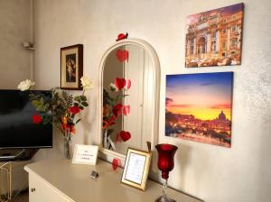 Zimmer mit einem Schreibtisch, einem TV und Blumen. in der Unterkunft metro C and Tor Vergata in Rom