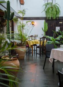 un restaurante con mesa, sillas y macetas en Hotel rural casona Santo Domingo, en Güímar