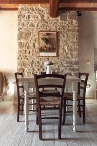 a dining room table with chairs and a stone wall at Mugello Vacanze Appartamenti Indipendenti in Scarperia