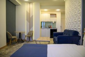 sala de estar con sofá azul y cocina en Rooftop Apart-Hotel en Ereván