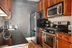 una cocina con electrodomésticos de acero inoxidable y armarios de madera en Deluxe Mount Vernon 2BR w WD nr Metro WDC-576 en Washington