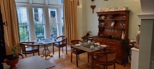 een eetkamer met tafels en stoelen en een groot raam bij Grosvenor House in Ilfracombe
