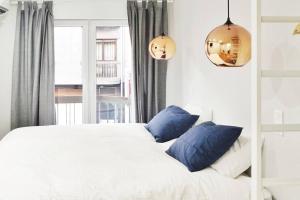 1 dormitorio con cama blanca y almohadas azules en Two Bedroom Terrace Sanctuary in the Center en Oporto