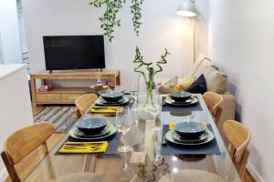 comedor con mesa con sillas y TV en Two Bedroom Terrace Sanctuary in the Center en Oporto