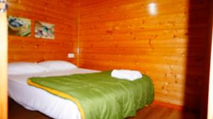 1 dormitorio con 1 cama en una habitación de madera en Bungalows Park Albufera, en El Saler