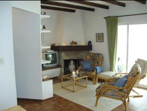 a living room with a fireplace and chairs and a tv at Casa Alberto - Altea in Altea