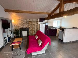uma sala de estar com um sofá vermelho e uma cozinha em Domaine de la moriniere em Commequiers