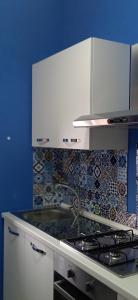cocina con fogones y pared azul en Le DueLamie, en Sessa Cilento