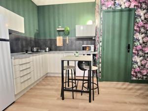 uma cozinha com uma pequena mesa e dois bancos em Cosy Break Jardins des plantes em Le Mans