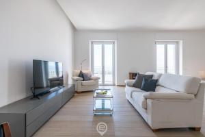 a living room with a white couch and a flat screen tv at Enchanting Panoramic Retreat in Cagliari