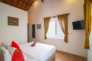 ein Schlafzimmer mit einem Bett und einem Fenster in der Unterkunft Be's Beach House An Bang in Hoi An