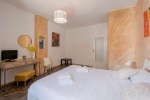 een slaapkamer met een groot wit bed en een bureau bij Licia Home - Air conditioning - Terrace in Sanremo