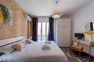 een slaapkamer met een groot wit bed en een bureau bij Licia Home - Air conditioning - Terrace in Sanremo