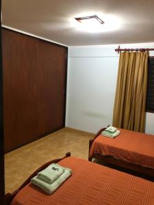 聖薩爾瓦多德胡胡伊的住宿－Samaraña depto Jujuy，客房设有两张床和一个带窗帘的窗户。