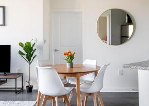 a dining room with a table and white chairs and a mirror at Kasa Alexandria Washington in Alexandria