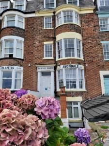 a building with a bunch of flowers in front of it at SeaView ground floor flat fast WiFi & FREE PARKING in Scarborough