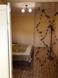 a bedroom with a bed and a wall with curtains at Elizabeth's Rooms in Kutaisi