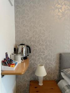 a room with a table with a coffee pot on a wall at Tudor Court Guest House in Falmouth