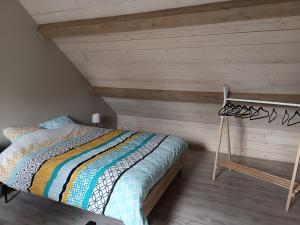 sypialnia z łóżkiem i drewnianą ścianą w obiekcie Clénoliette w mieście Cerfontaine