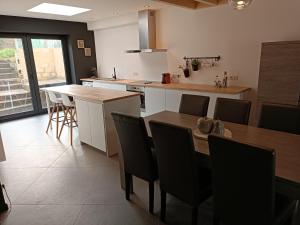a kitchen with a table and chairs and a kitchen with a counter at Clénoliette in Cerfontaine