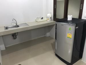 a bathroom with a sink and a small refrigerator at TandT House in Lamai