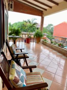 een veranda met 2 stoelen en een patio bij Casa Glamour in Trinidad