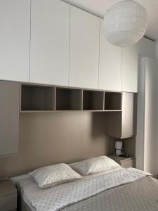 a bedroom with a bed and white cabinets at Palace Central Suites in Iaşi