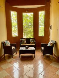 ein Wohnzimmer mit einem Sofa und 2 Stühlen in der Unterkunft Casa Glamour in Trinidad
