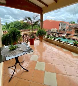 een patio met een tafel en uitzicht op een balkon bij Casa Glamour in Trinidad