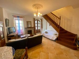 sala de estar con escalera y sofá en Charmant appartement T2 65m², en Quenza