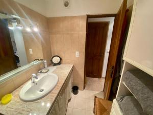 y baño con lavabo y espejo. en Charmant appartement T2 65m², en Quenza