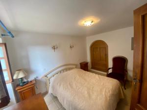 1 dormitorio con cama, escritorio y silla en Charmant appartement T2 65m², en Quenza