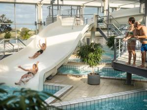 a group of people on a slide in a swimming pool at Landal Rnbjerg in Ranum