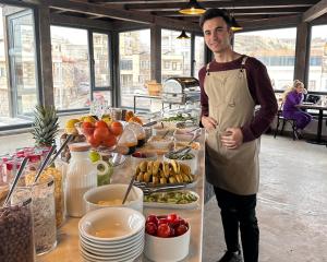a man in an apron standing next to a buffet of food at Osmanli Cappadocia Hotel in Goreme