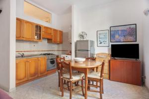 une cuisine avec une table et des chaises ainsi qu'une télévision dans l'établissement House Mario, à Levanto