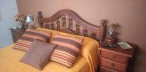1 cama con 2 almohadas y cabecero de madera en Rancho Aparte en Salta