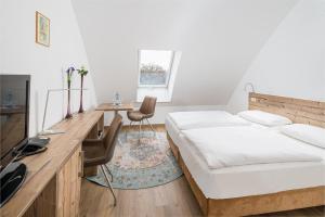 1 Schlafzimmer mit 2 Betten, einem Schreibtisch und einem TV in der Unterkunft Haus am Spreebogen in Fürstenwalde