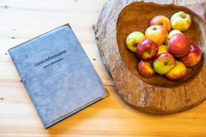 a wooden bowl of apples and a book on a table at Gasthof Fischerwirt in Zeutschach