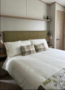 a large white bed with two pillows on it at Sea La Vie in Cayton