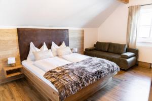 una camera con un grande letto e un divano di Gasthof Fischerwirt a Zeutschach