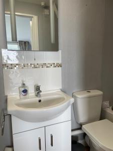 a white bathroom with a sink and a toilet at Tudor Court Guest House in Falmouth