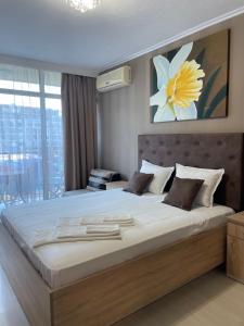 a large bed in a bedroom with a large window at Apart hotel Gallery L in Sunny Beach +69 photos